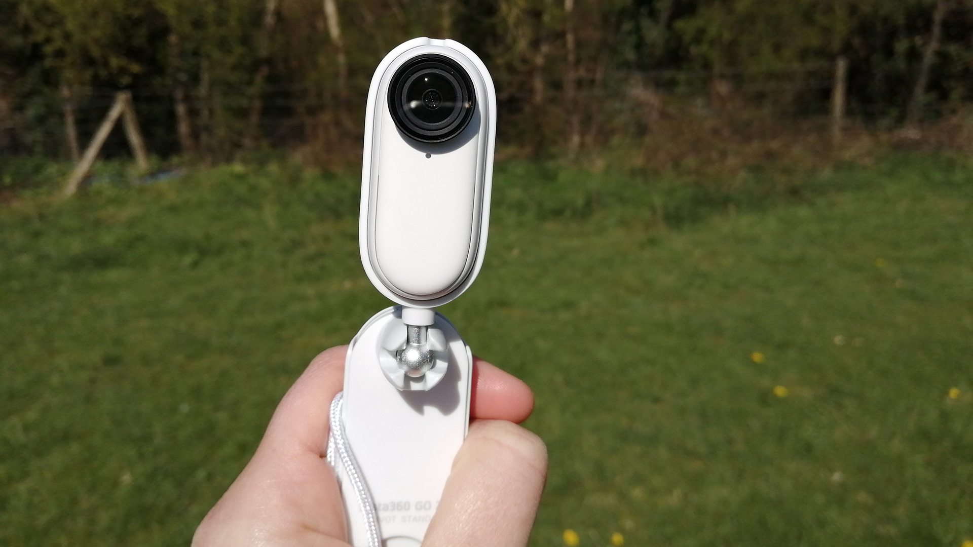 Insta360 GO 2 держится на фоне травы