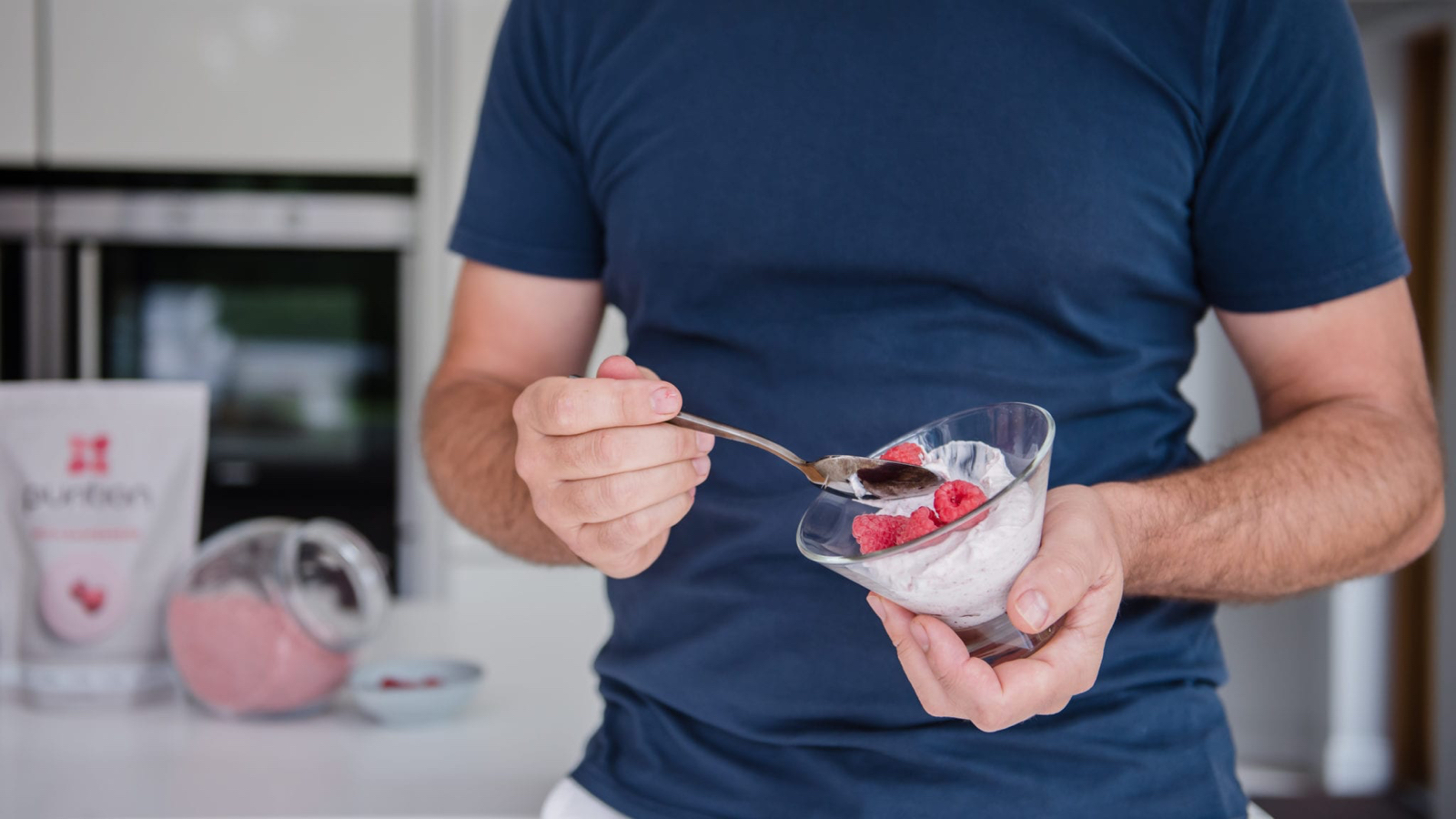 Мужчина черпает протеиновый десерт из стеклянной миски