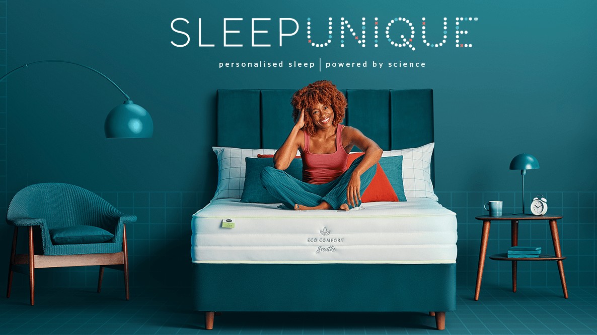 Женщина сидела на кровати под логотипом Sleepunique