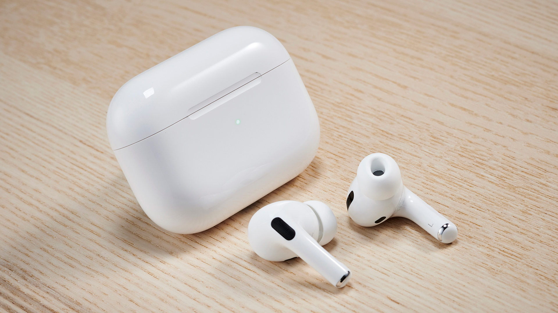 AirPods Pro вне футляра на деревянной поверхности