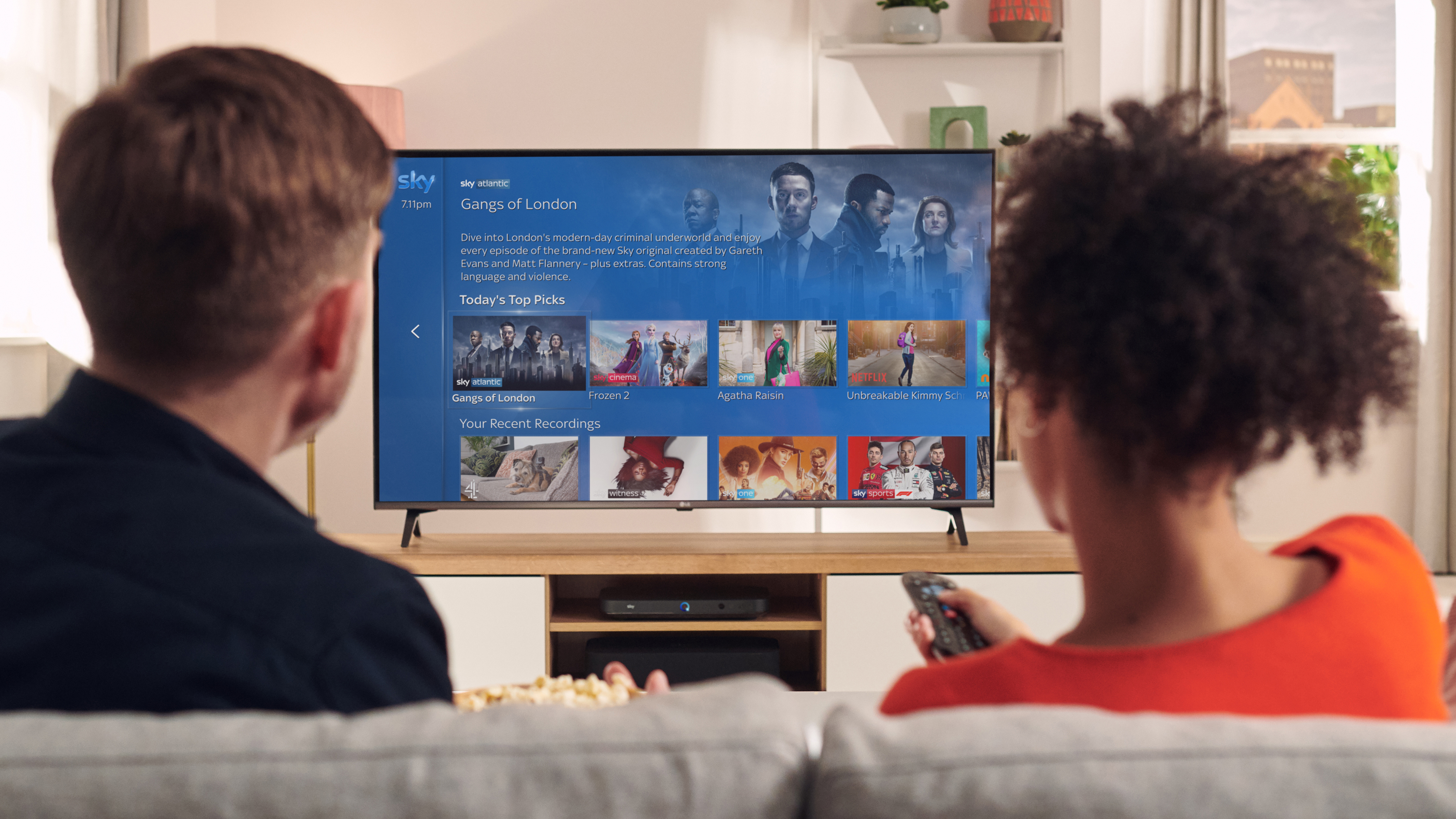 Мужчина и женщина смотрят Sky TV на приставке Sky Q, подключенной к телевизору 4K.