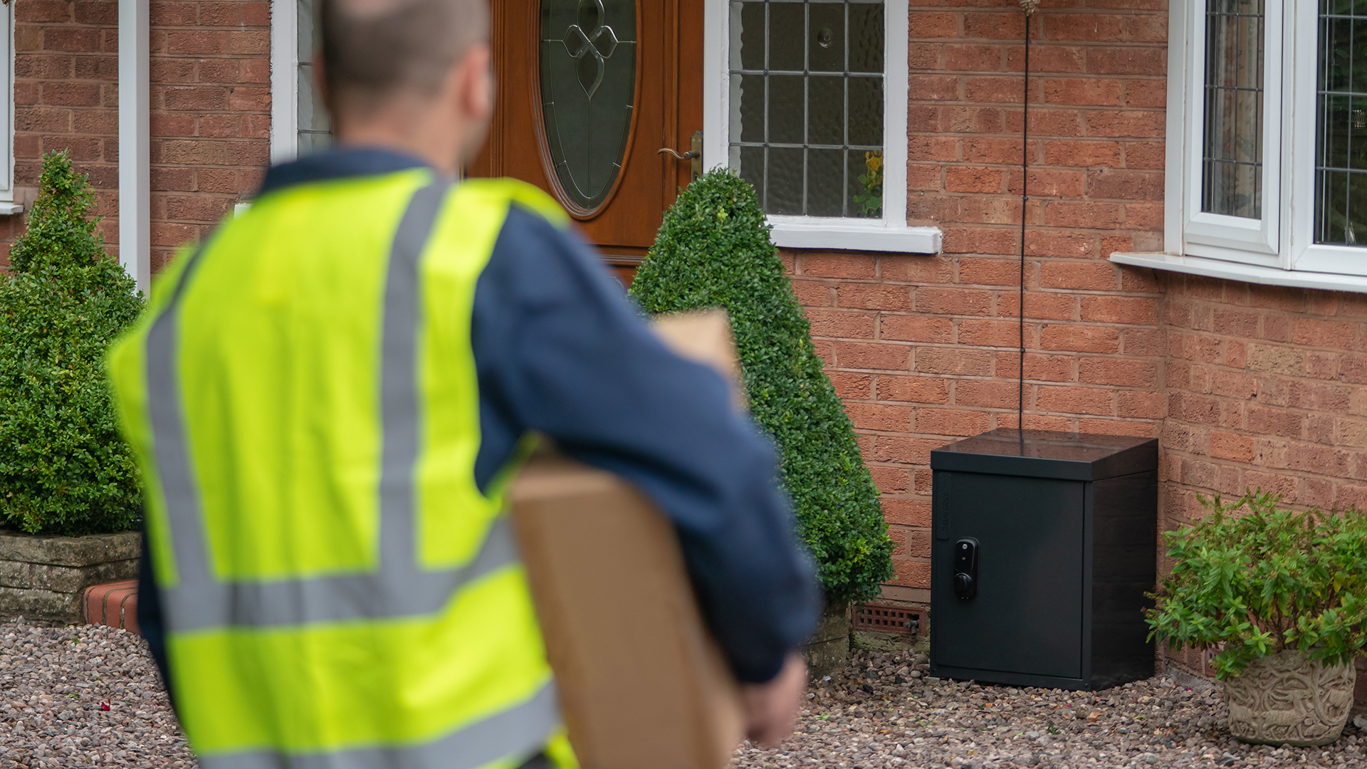 Водитель-экспедитор приближается с Yale Smart Delivery Box