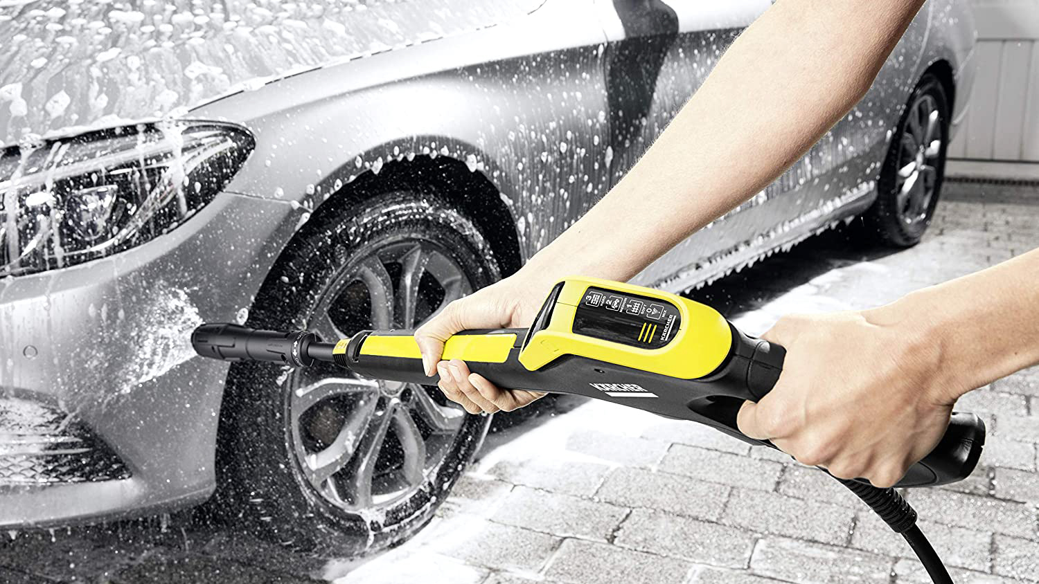 Мойка высокого давления Karcher используется для мытья серебристого автомобиля