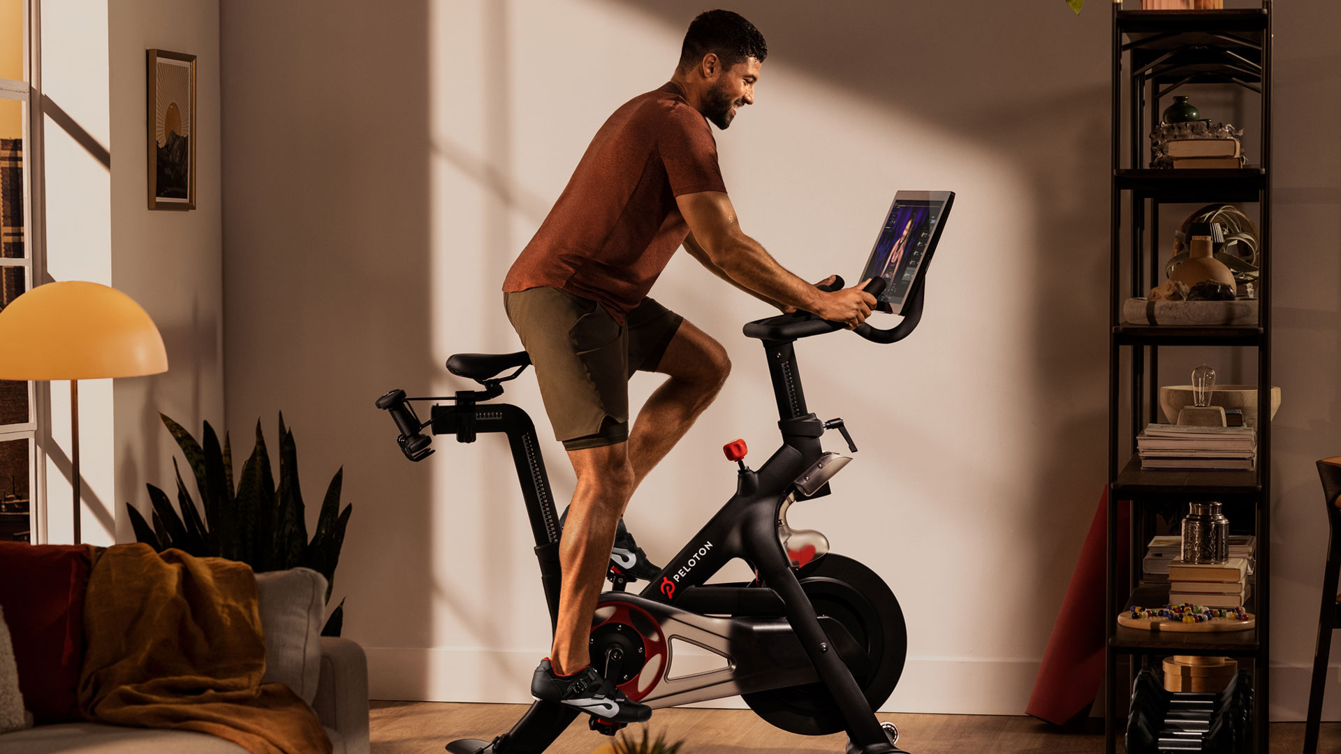 Сколько стоит велосипед Peloton?  На изображении изображен мужчина, катающийся на велосипеде Peloton.