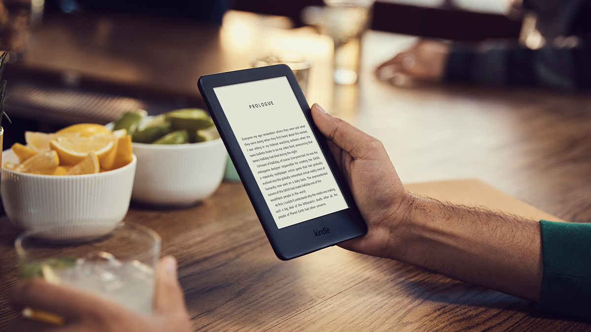 Электронная книга Amazon Kindle держится в руке мужчины