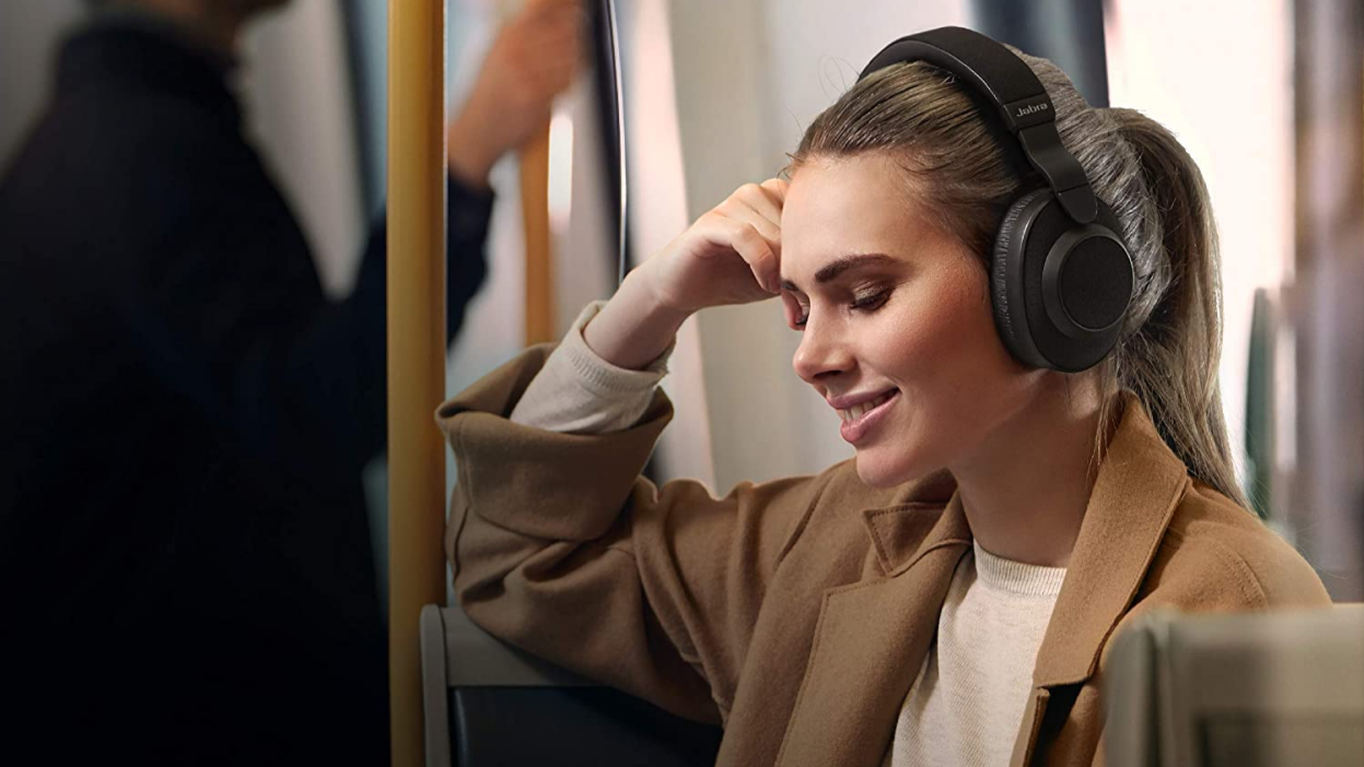 Беспроводные наушники Jabra Elite 85h с шумоподавлением, которые носит женщина в поезде метро