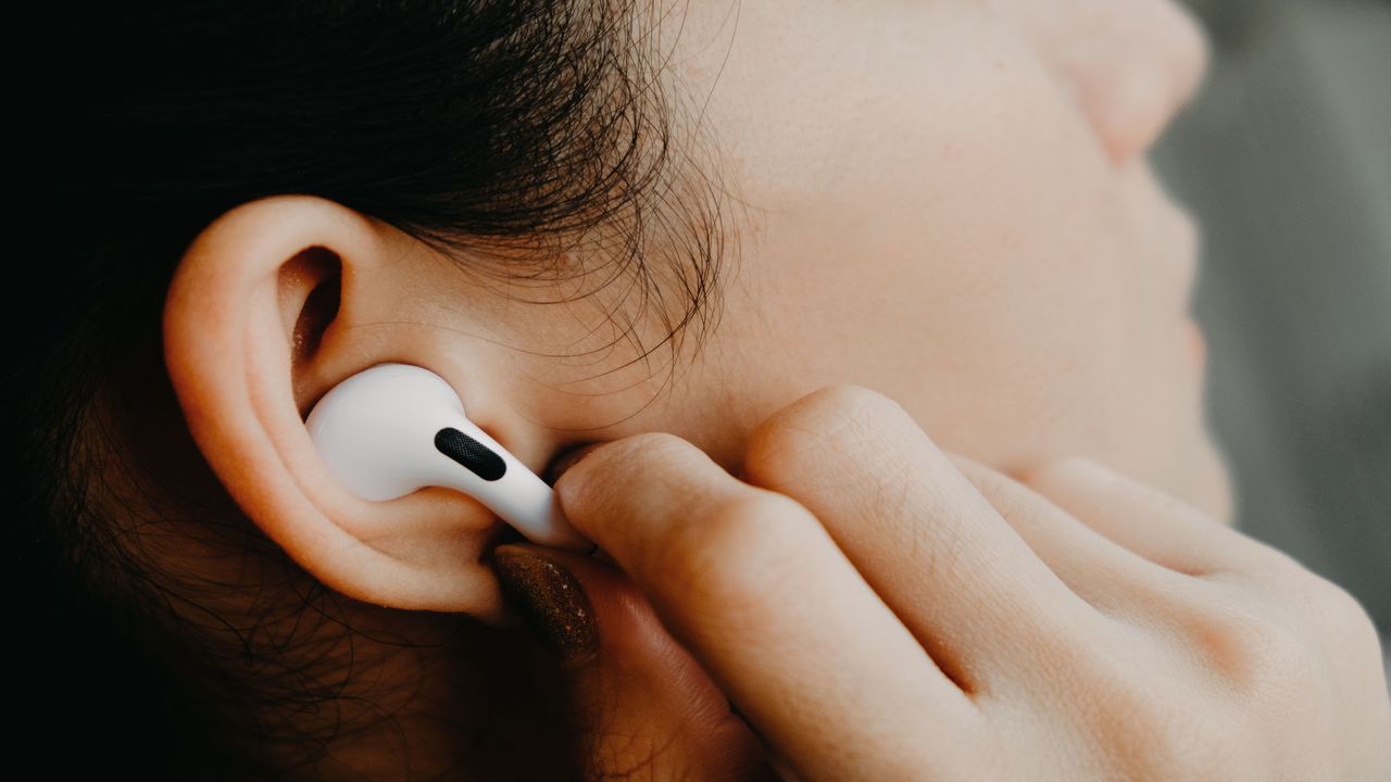 Apple AirPods Pro носит женщина с черными волосами