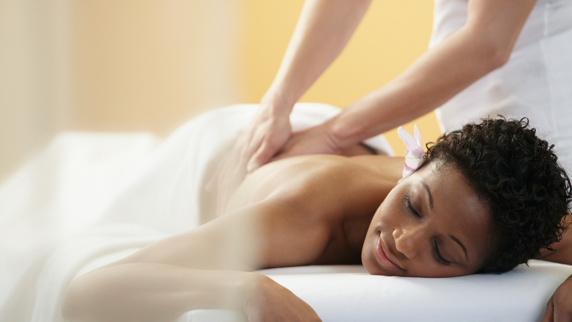 Женщина лежит на животе на массаже. Lee massage