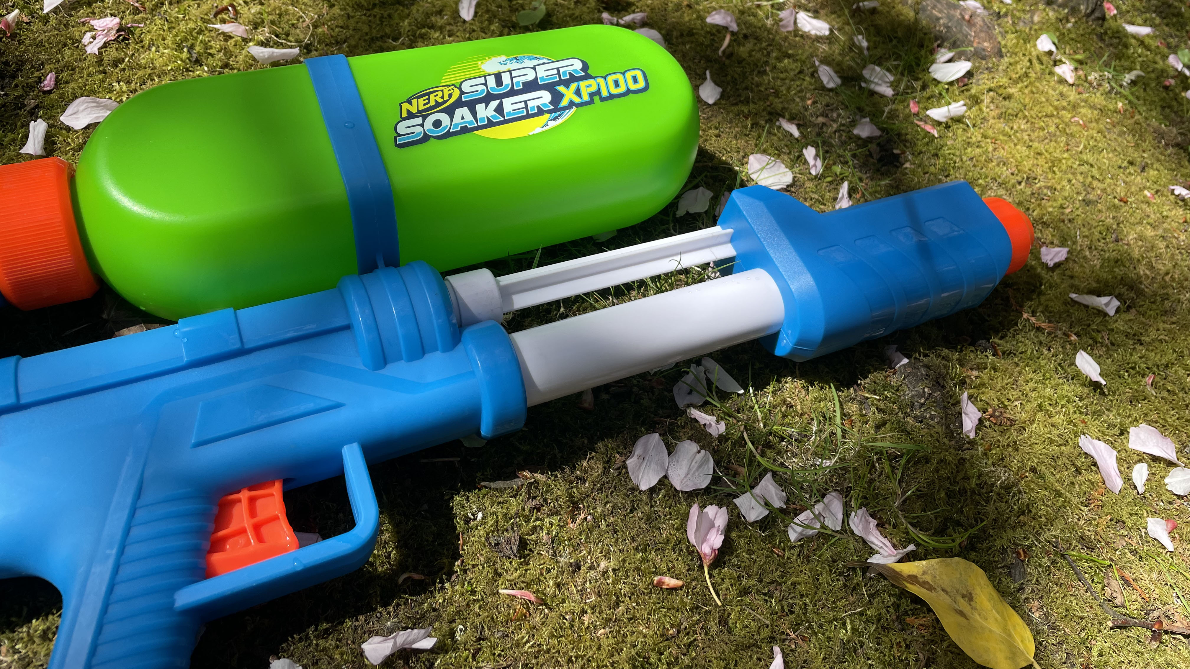 Водяной бластер Super Soaker XP100 лежит на траве