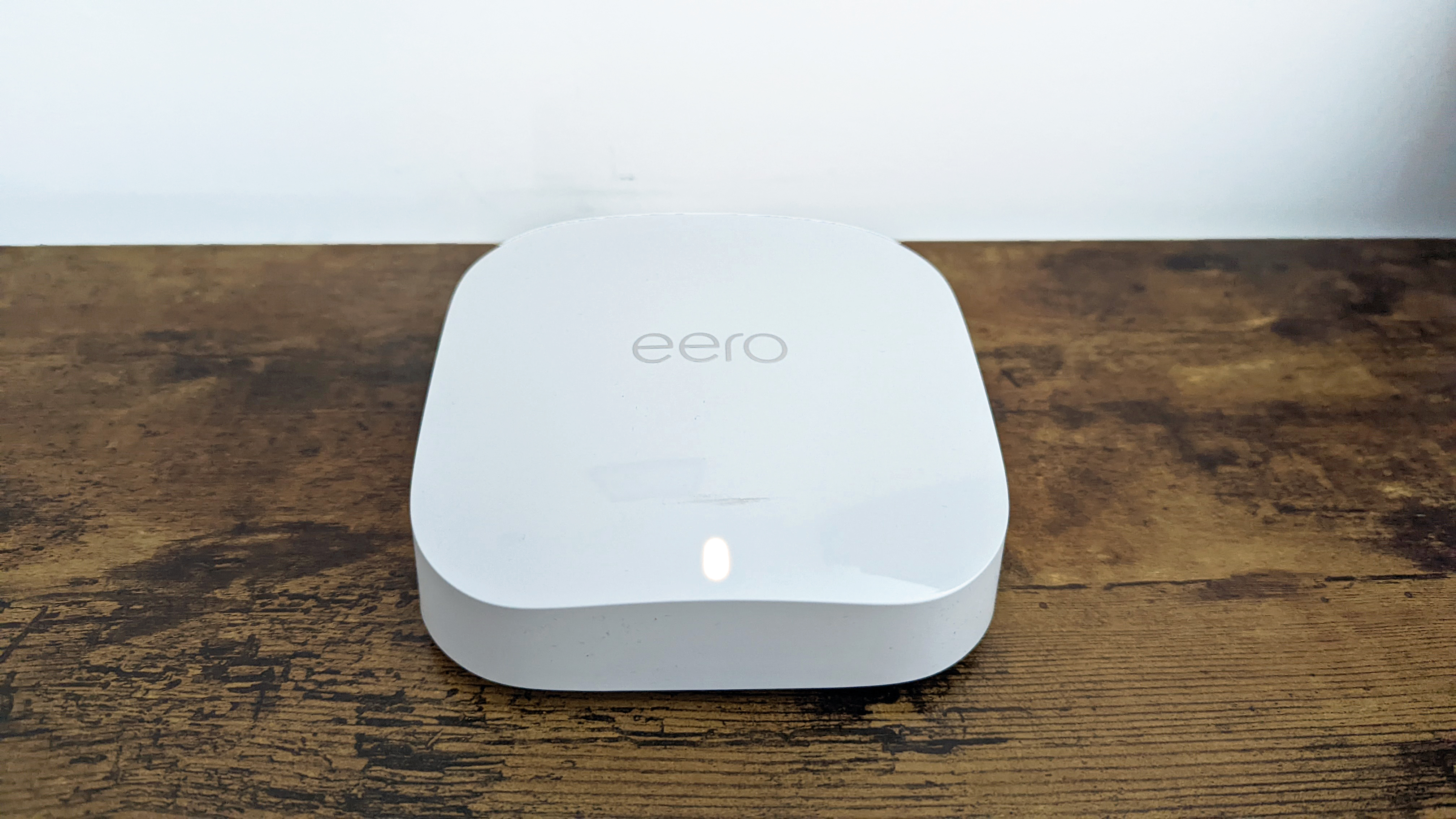 Обзор Amazon Eero Pro 6E: мужчина играет в видеоигры с ячеистым Wi-Fi-маршрутизатором за своим компьютером