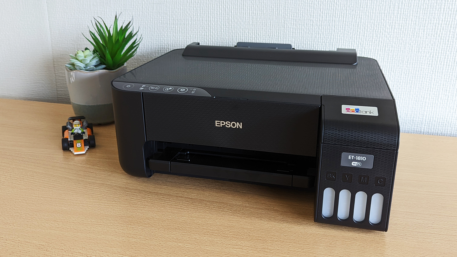 Вид спереди на принтер Epson EcoTank ET-1810, стоящий на столе