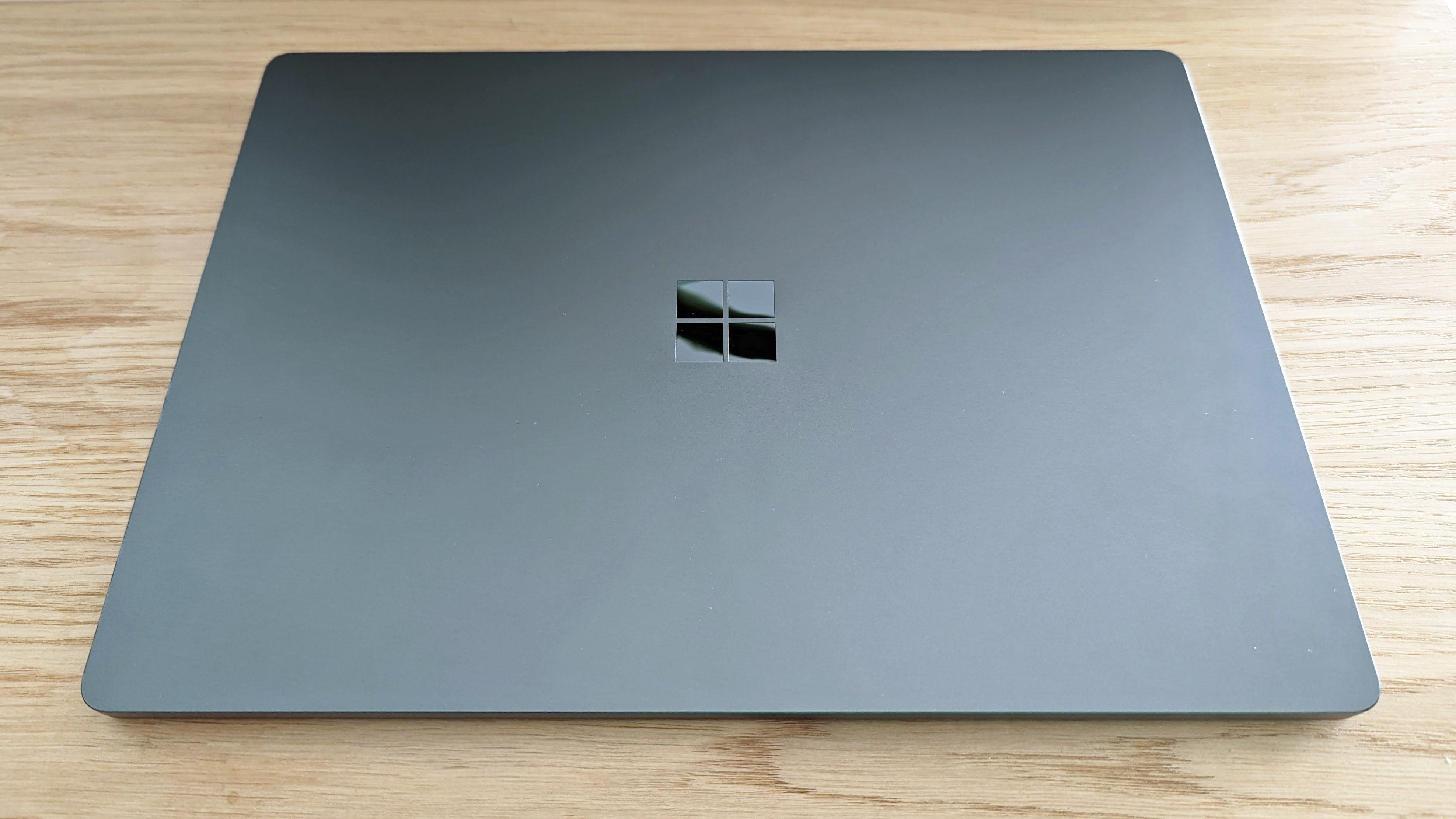 Обзор Microsoft Surface Laptop 5: ноутбук закрыт на деревянном столе