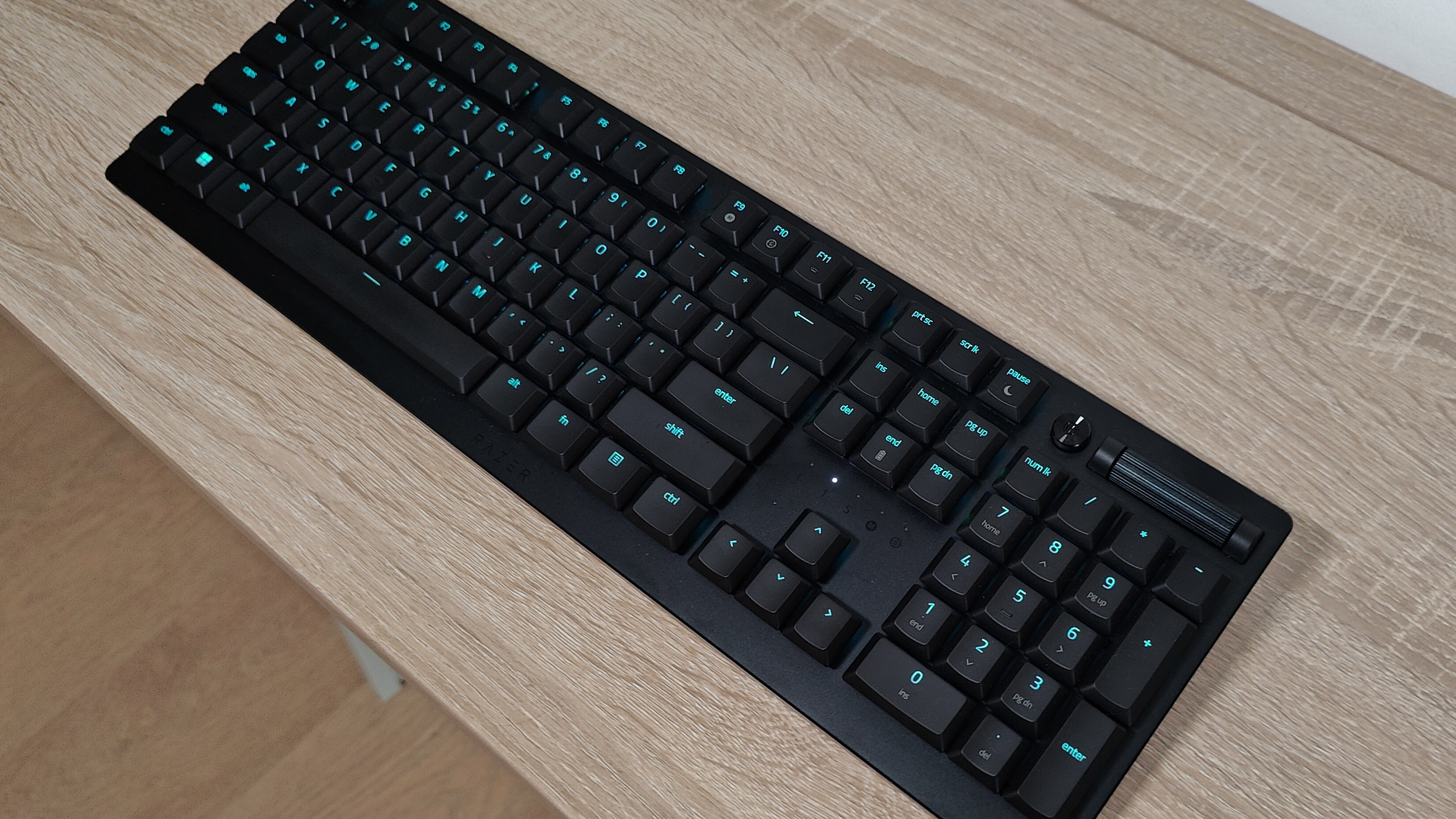 Обзор Razer Deathstalker V2 Pro: черная клавиатура с синей подсветкой на столе