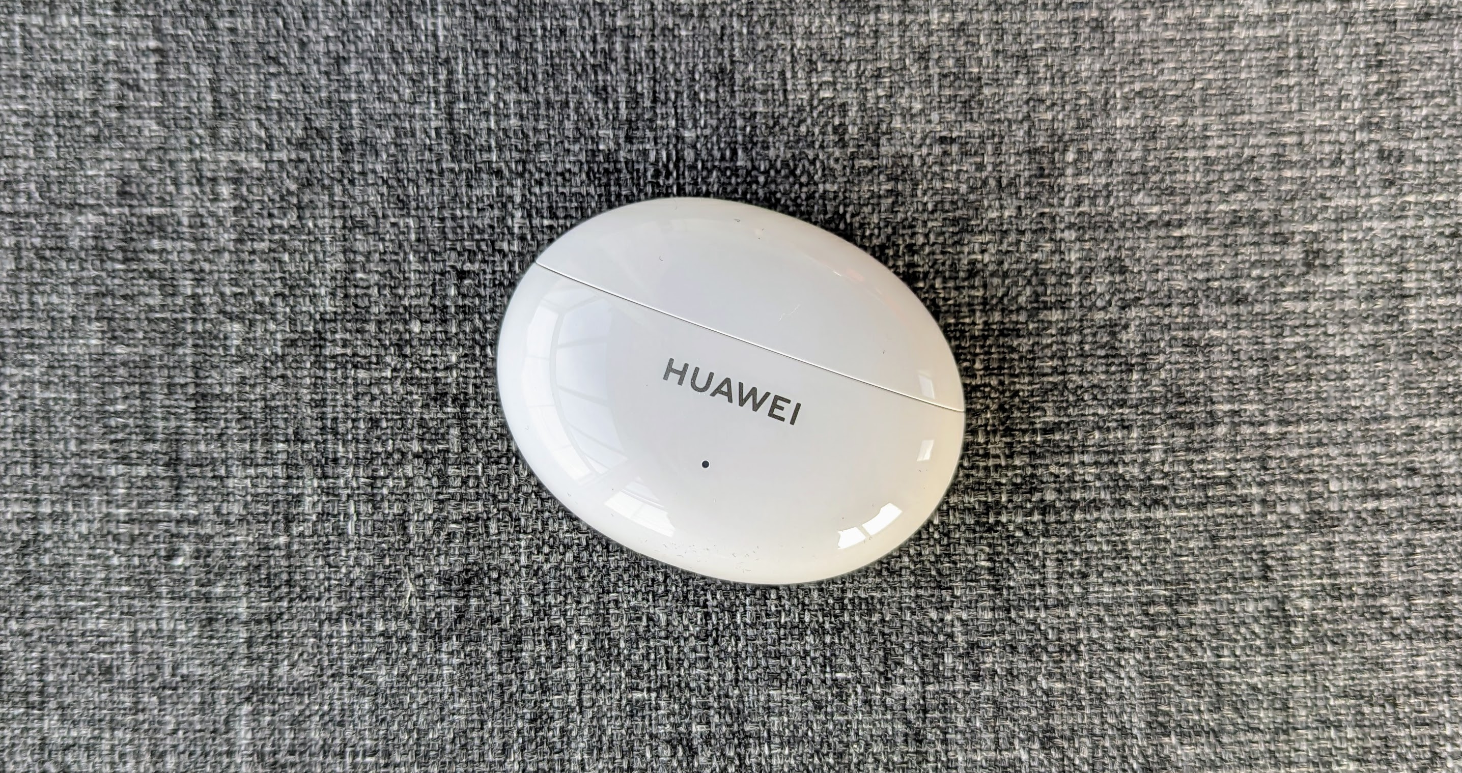 Обзор Huawei Freebuds 5i: чехол для зарядки на сером фоне