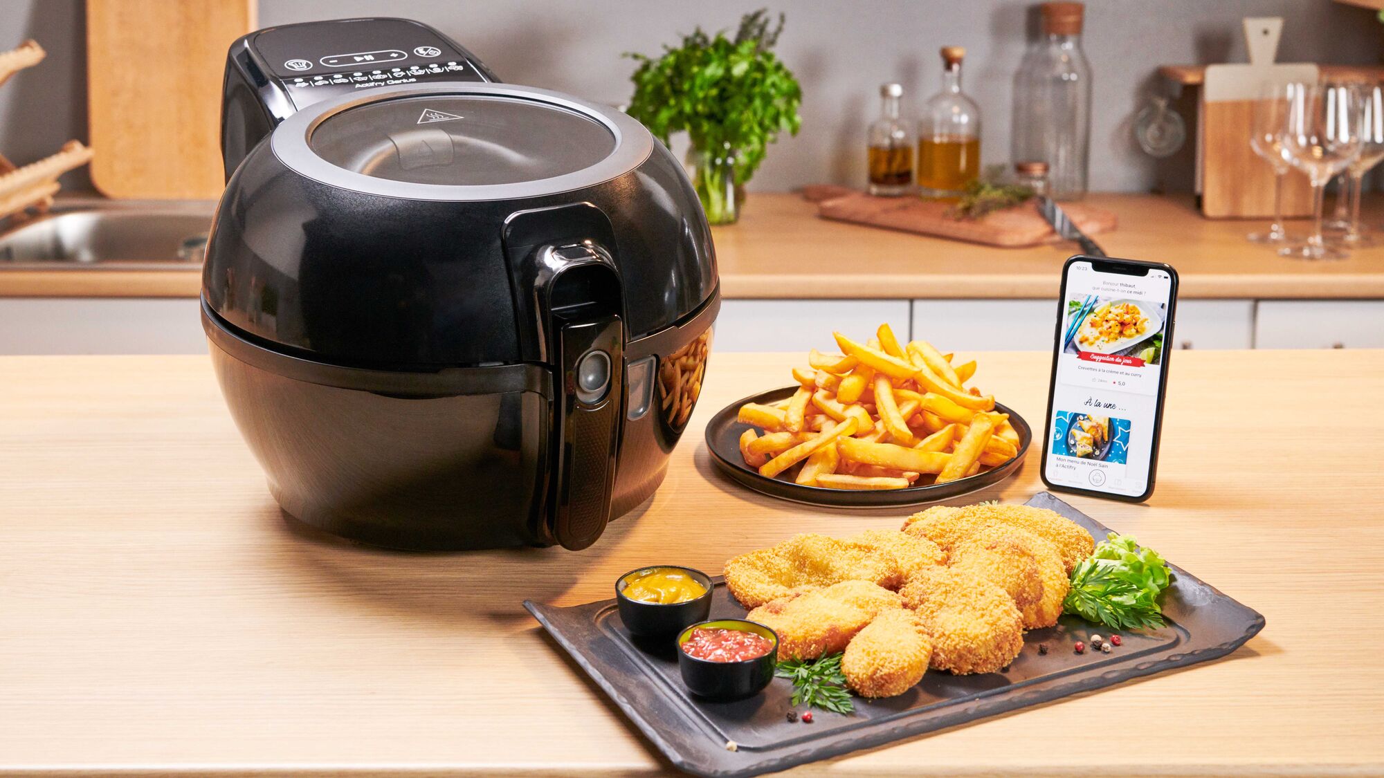 Фритюрница Tefal ActiFry Genius+ на деревянной столешнице в окружении еды