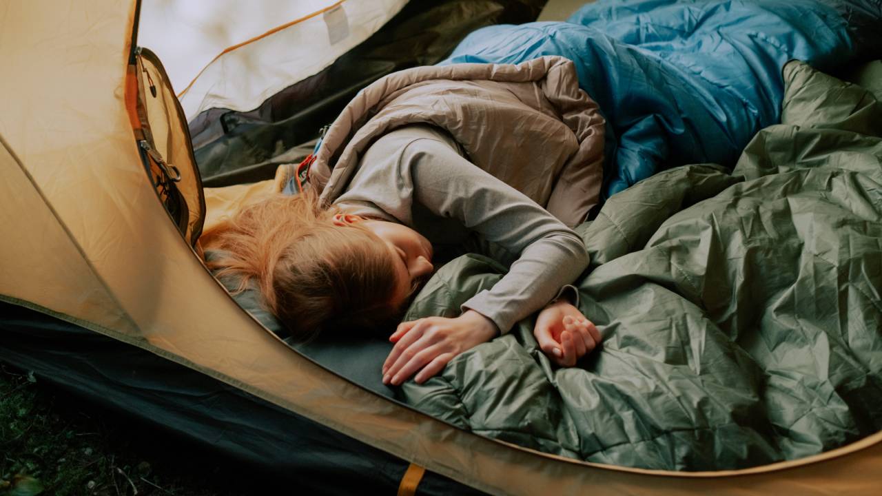 Женщина спит в палатке